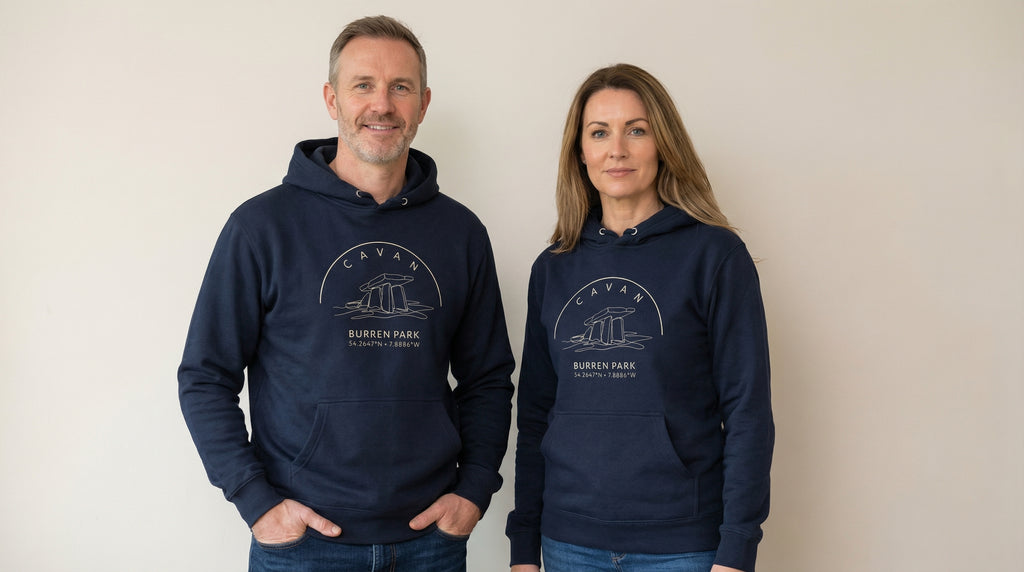 Two people wearing navy blue hoodies with a logo and text on a plain background
