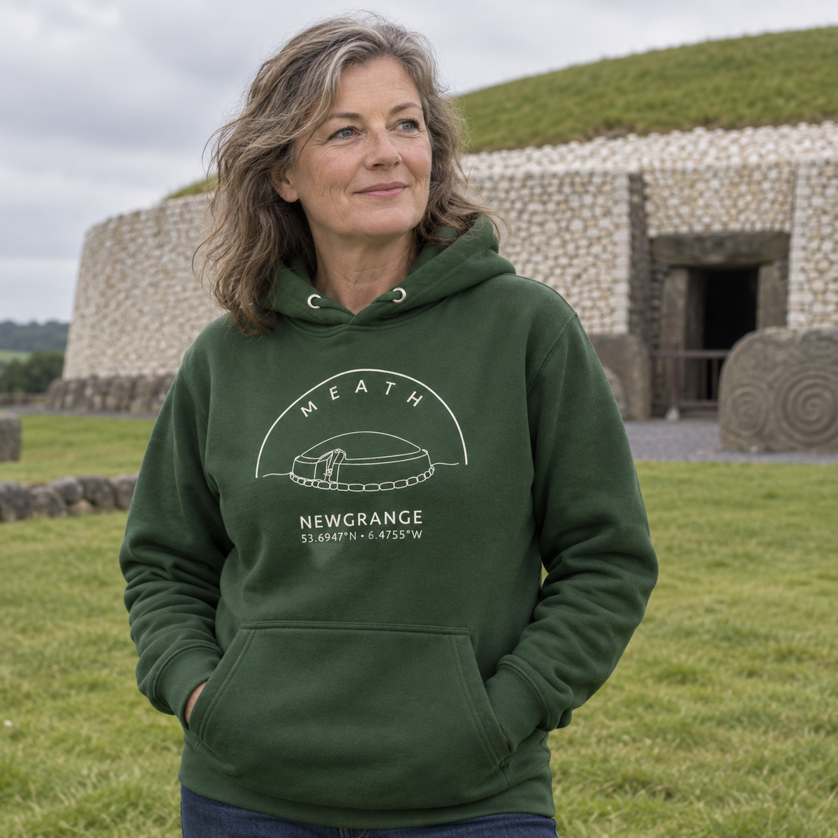 Woman wearing the Meath Newgrange forest green hoodie at Newgrange